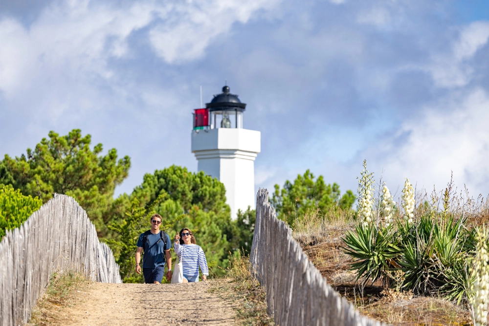 Couple en promenade vers le phare de La Tranche sur Mer pour découvrir le patrimoine de la Côte de Lumière