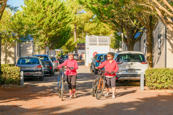 femmes souriantes qui marchent à côté de leur vélo à la Tranche sur Mer